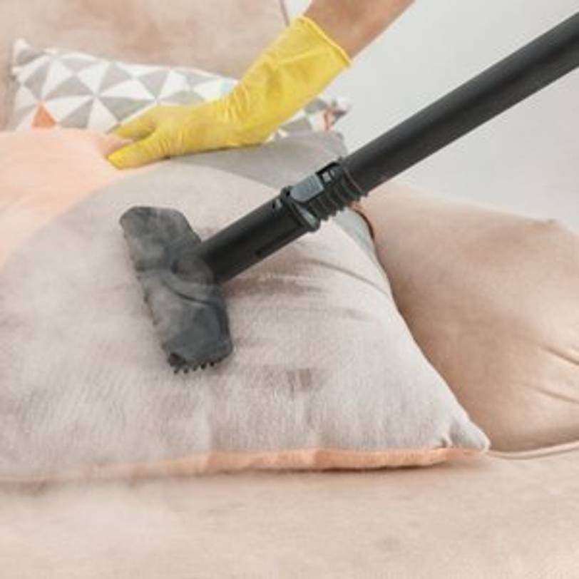 kissen wird mit dampfreiniger bearbeitet