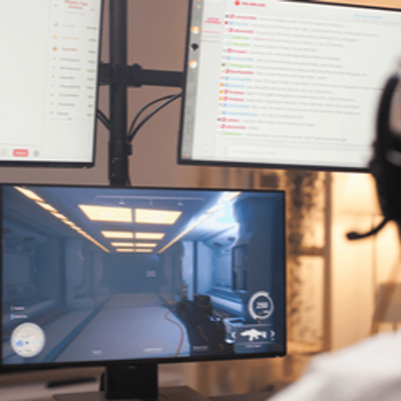 junger mann nutzt drei monitore gleichzeitig